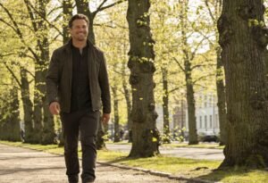Alegria: homem sorrindo espontaneamente caminhando ao ar livre