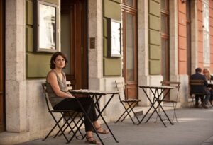 Desprezo: mulher sentada sozinha em mesa de café com expressão séria