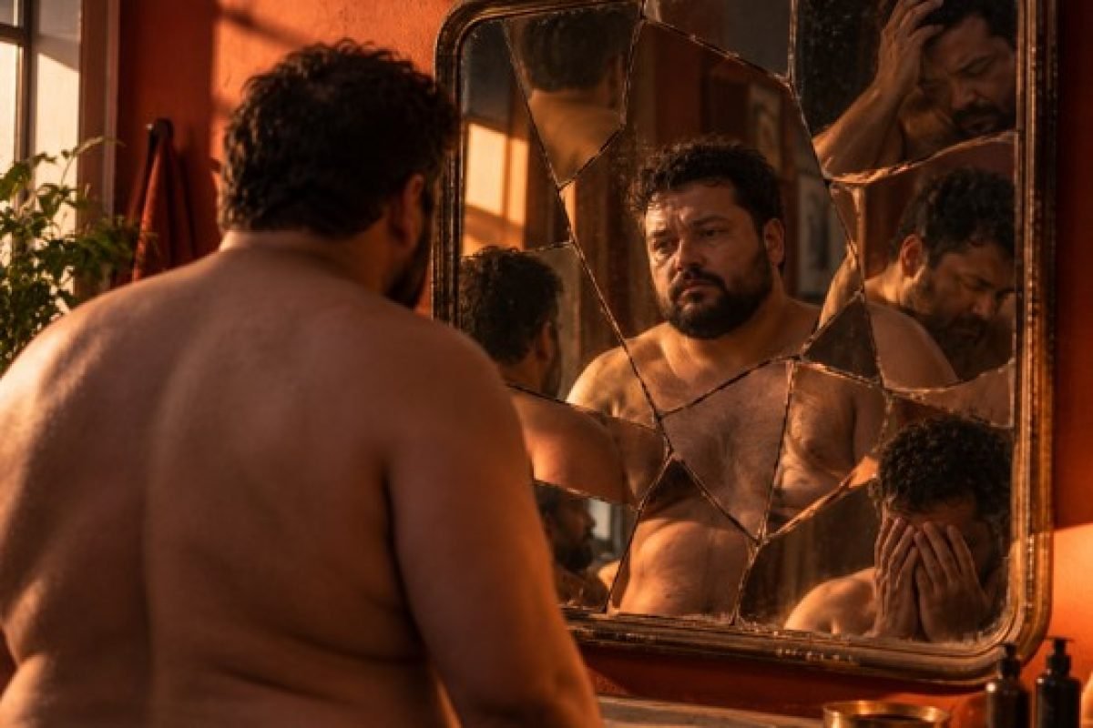 Adulto diante de espelho rachado com reflexo fragmentado em múltiplas partes, ilustrando a autoimagem negativa e a dissociação no trauma complexo (CPTSD)